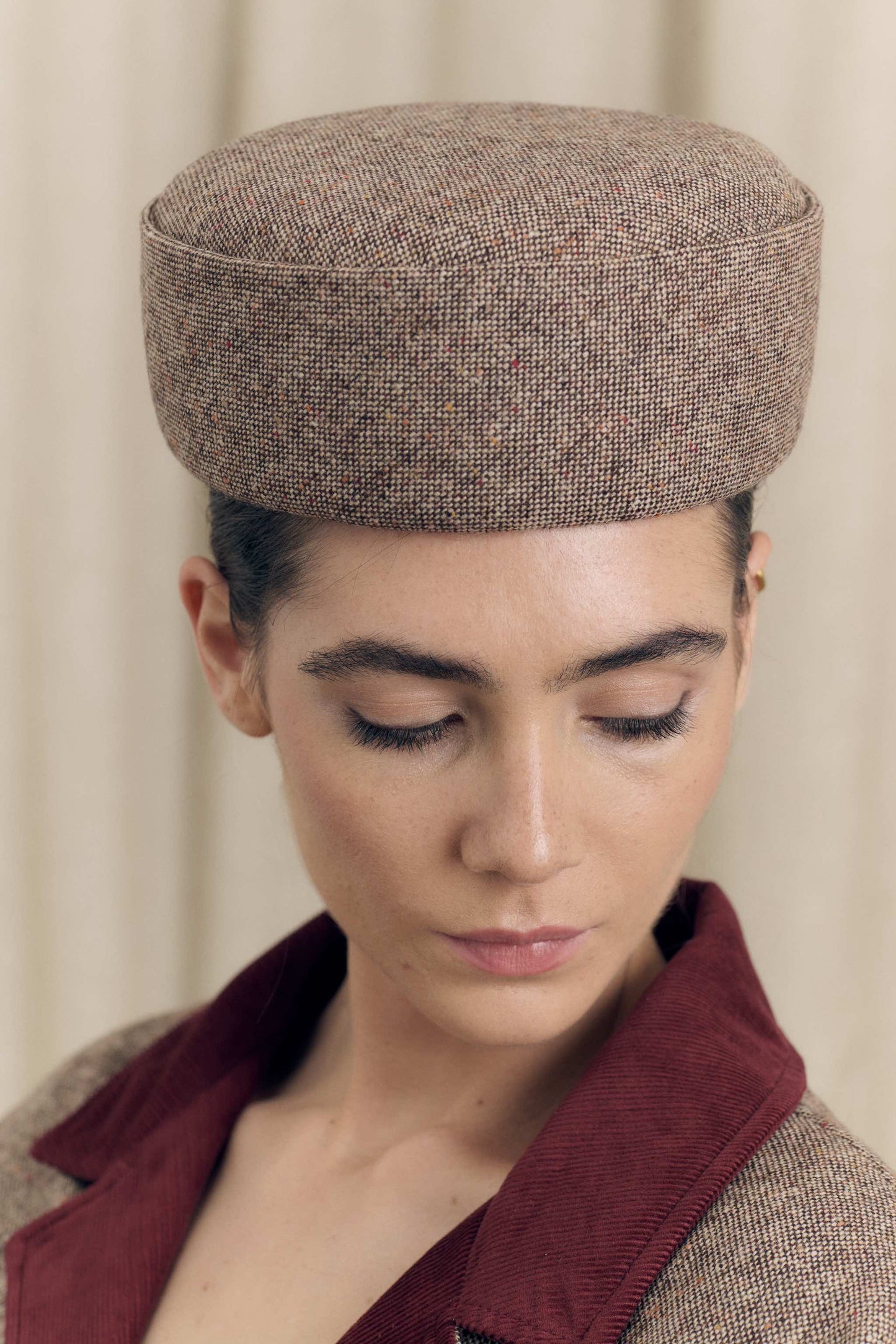 Model wearing Botteghe Oscure pillbox hat, handmade in Italy in tweed wool.