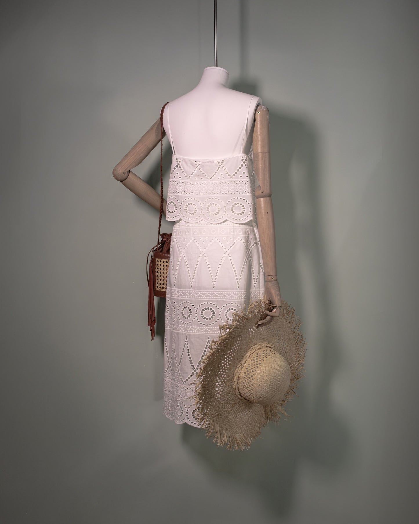 White cotton batiste top with broderie anglaise embroidery styled with the matching skirt and handcrafted bucket bag, back view.