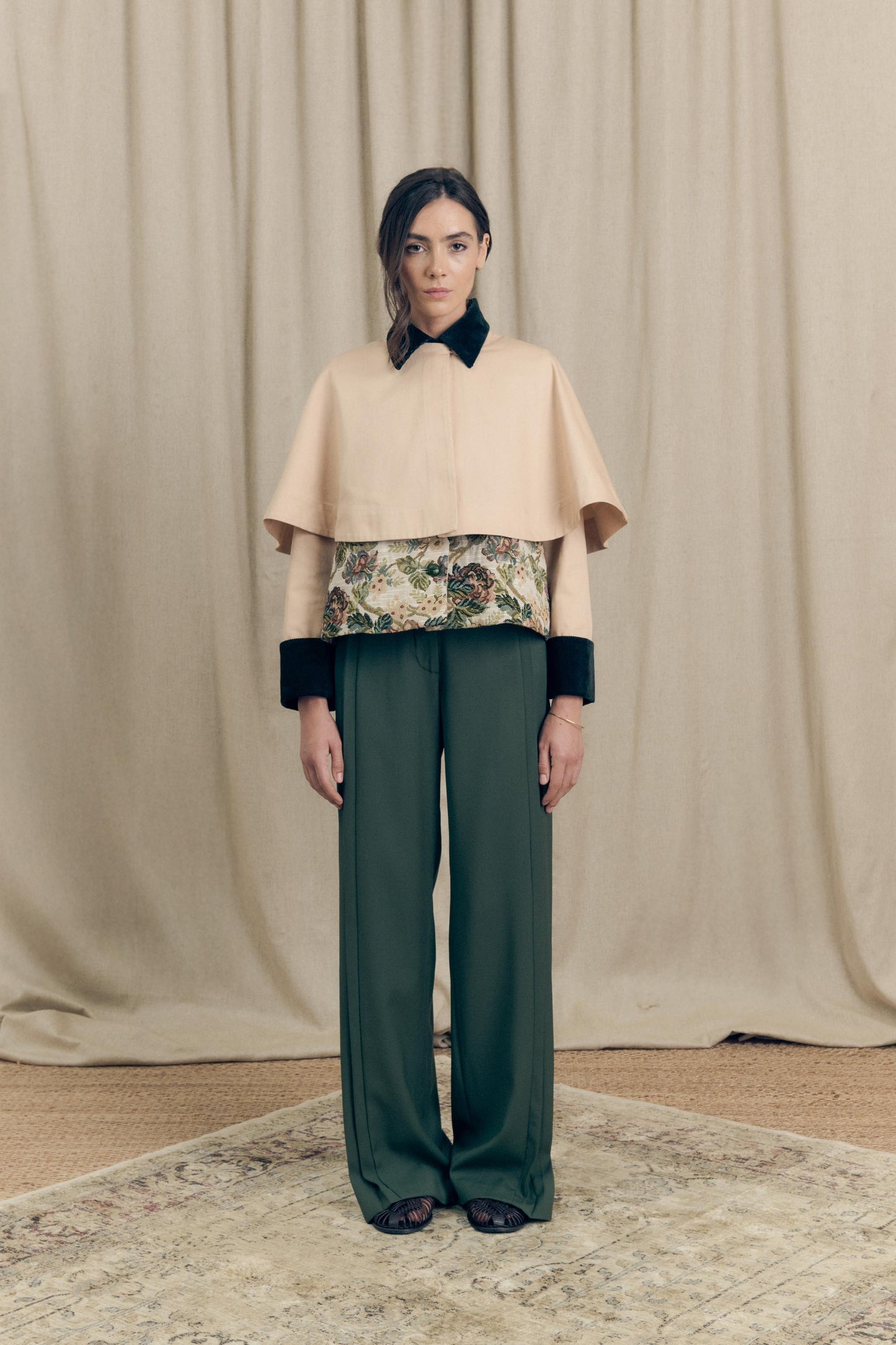 Front view of the Heatherfield Jacket by Botteghe Oscure, showcasing the structured silhouette, removable capelet in cotton twill, floral jacquard body, and velvet collar with leather-woven buttons.