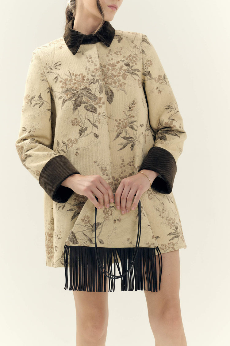 Handcrafted handbag with vintage floral jacquard and brown leather fringe, worn with matching jacquard coat by Botteghe Oscure. 100% Made in Italy.