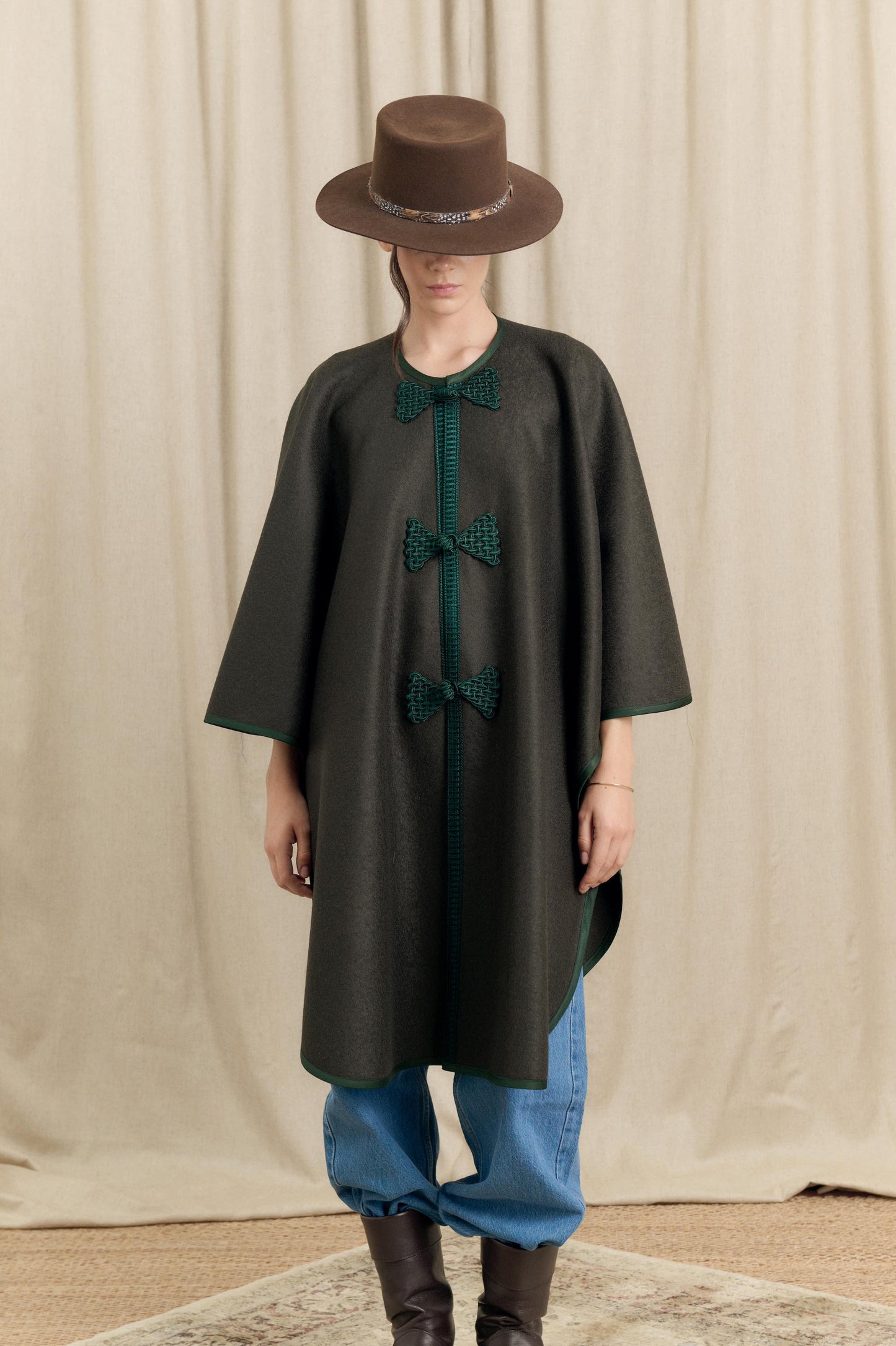 Close-up of handmade frog closures and gros-grain trim on Botteghe Oscure loden wool cape