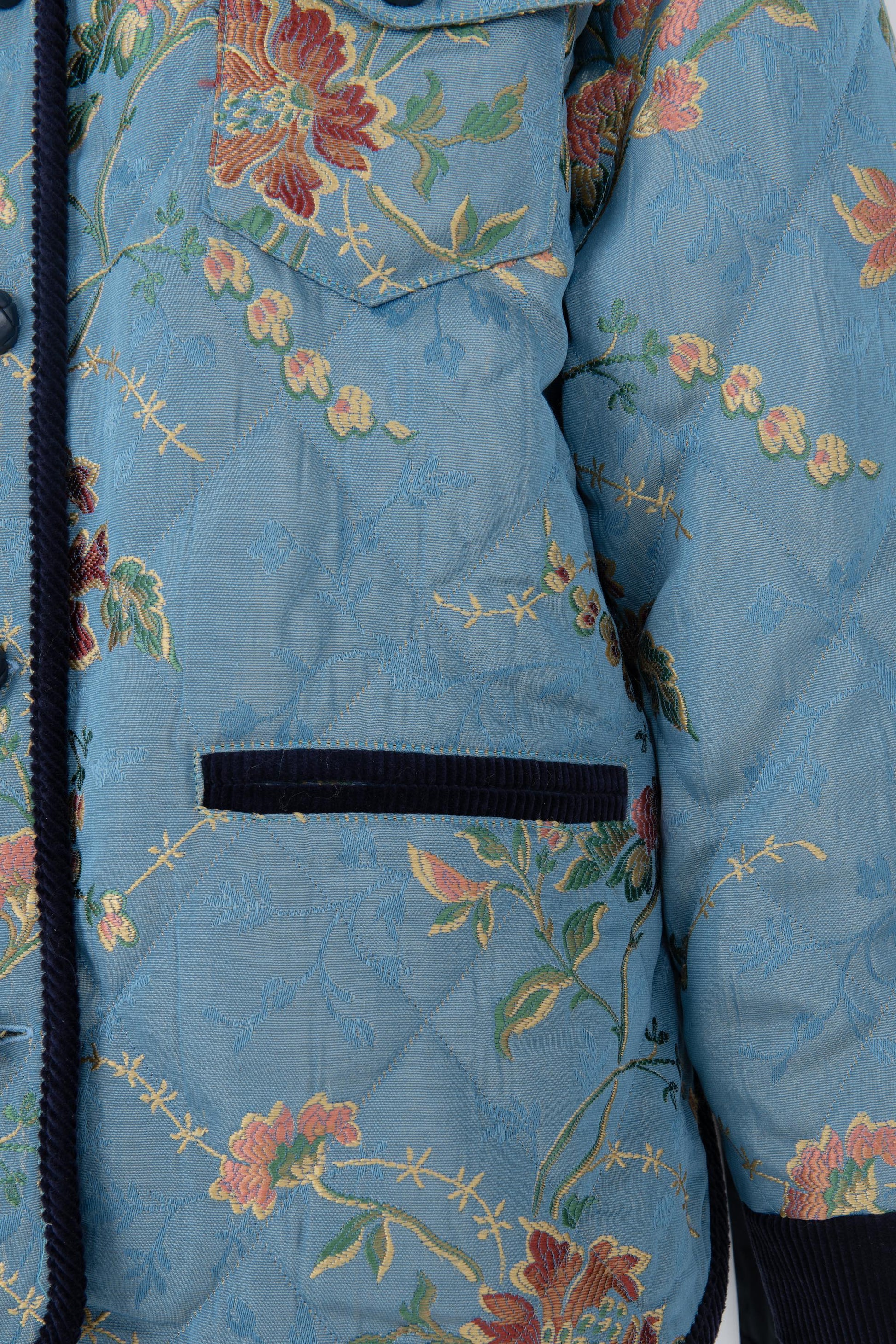 Close-up of the floral lampas cotton fabric and navy velvet trims of the Botteghe Oscure quilted jacket.