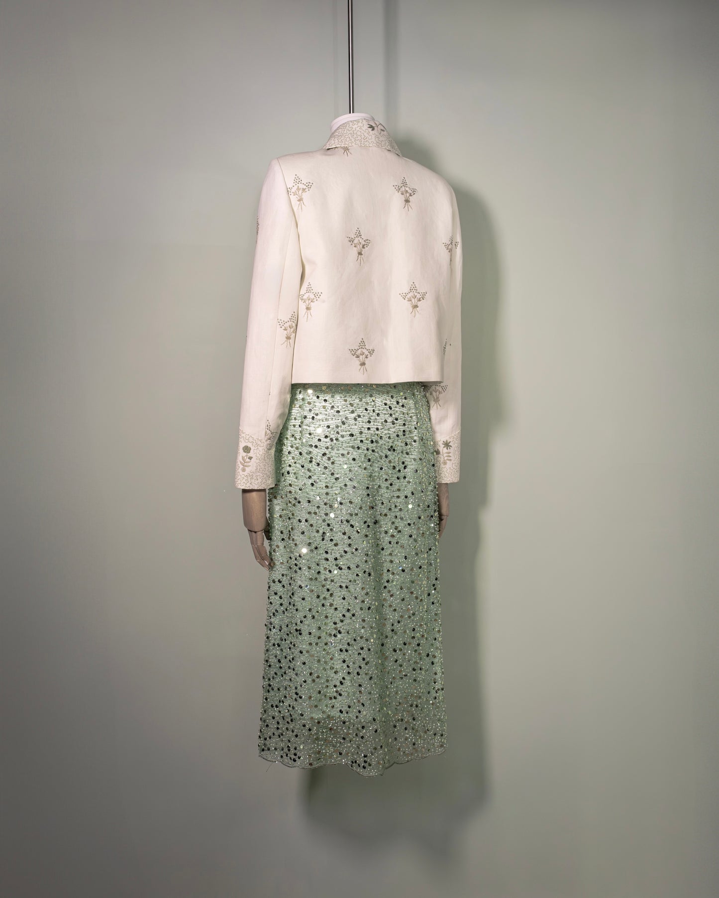 Botteghe Oscure Carré Jacket in archival English linen with hand-embroidered floral bouquets, styled with sequins embroidered skirt and silk flower brooch, front view.