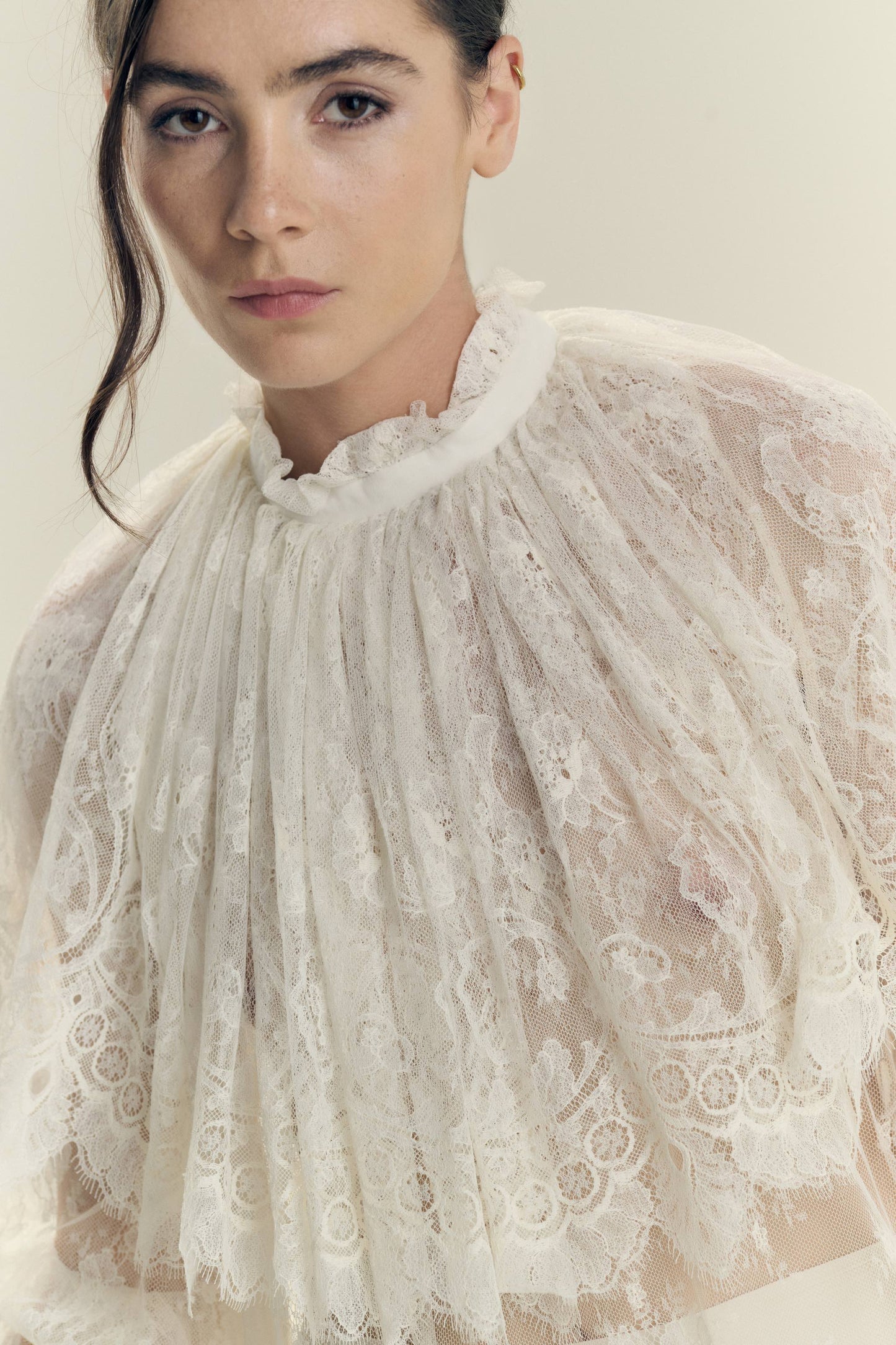Model wearing Botteghe Oscure dress in French Chantilly lace with draped lace capelet and silk details – front view