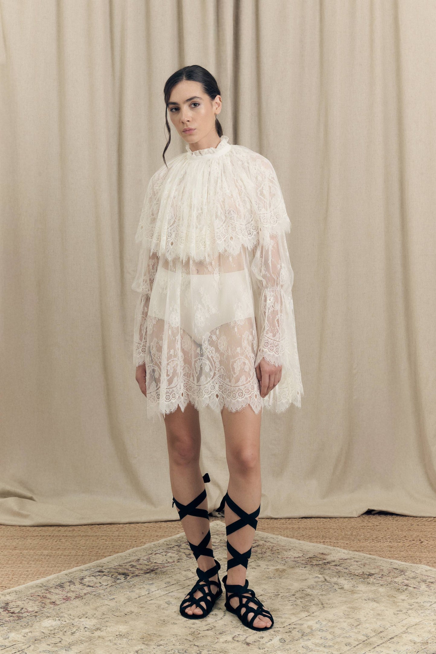 Model wearing Botteghe Oscure dress in French Chantilly lace with draped lace capelet and silk details – front view