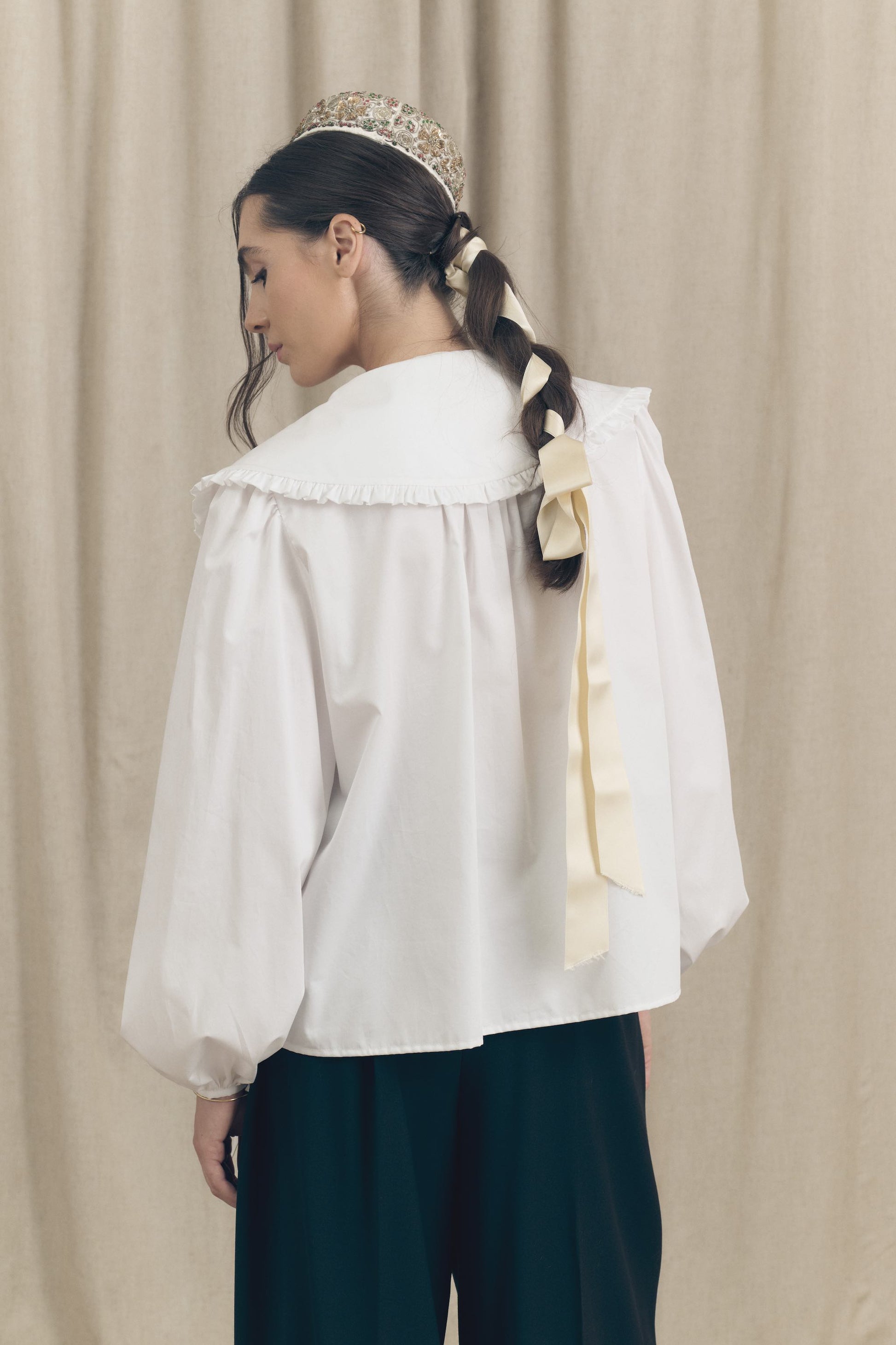 Model wearing a white cotton oversize shirt with ruffle collar and 1930s vintage buttons by Botteghe Oscure – back view