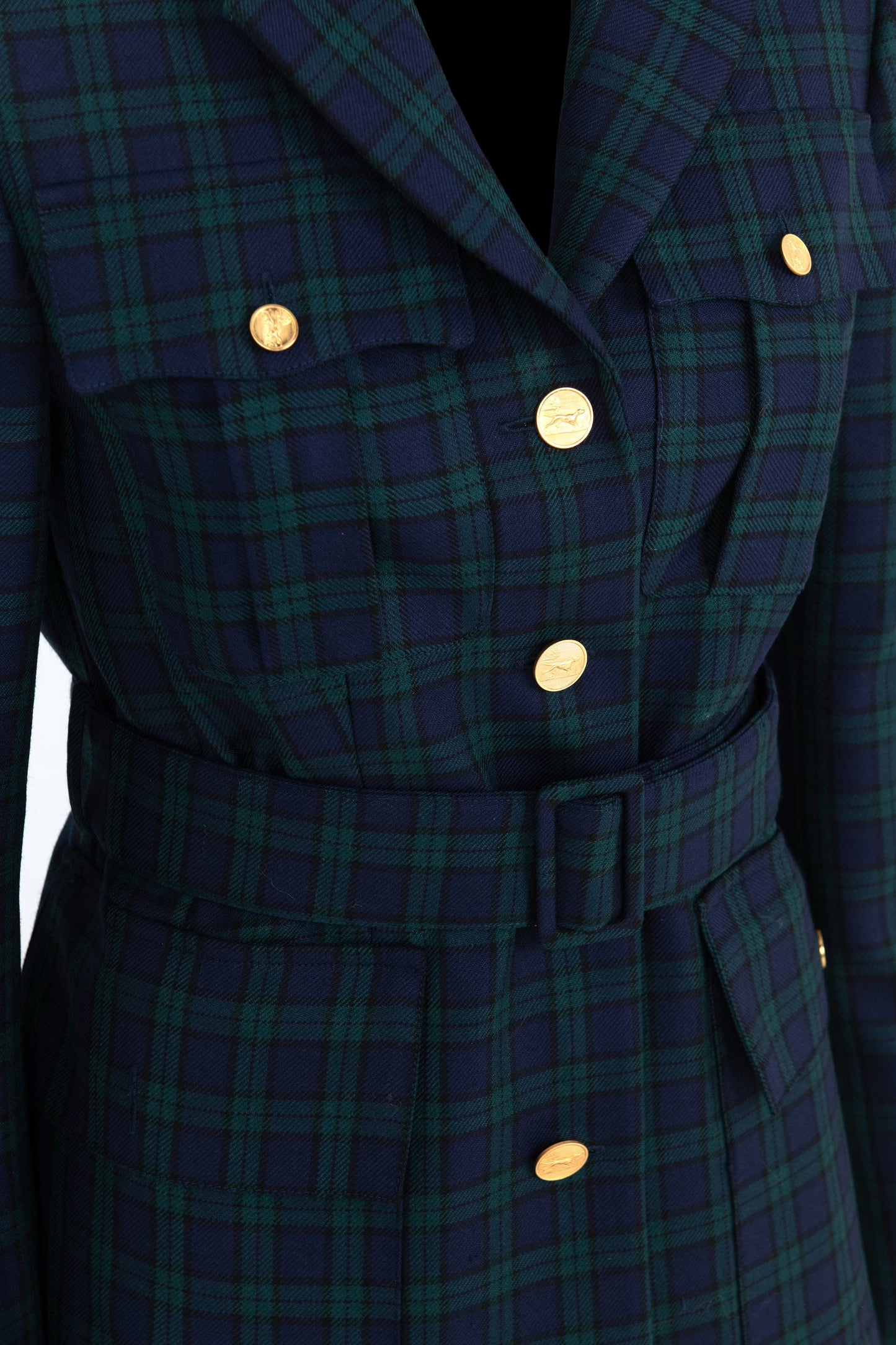 Close-up of Black Watch wool blazer showing engraved gold buttons, structured flaps, and tailored chest pocketsby Botteghe Oscure.