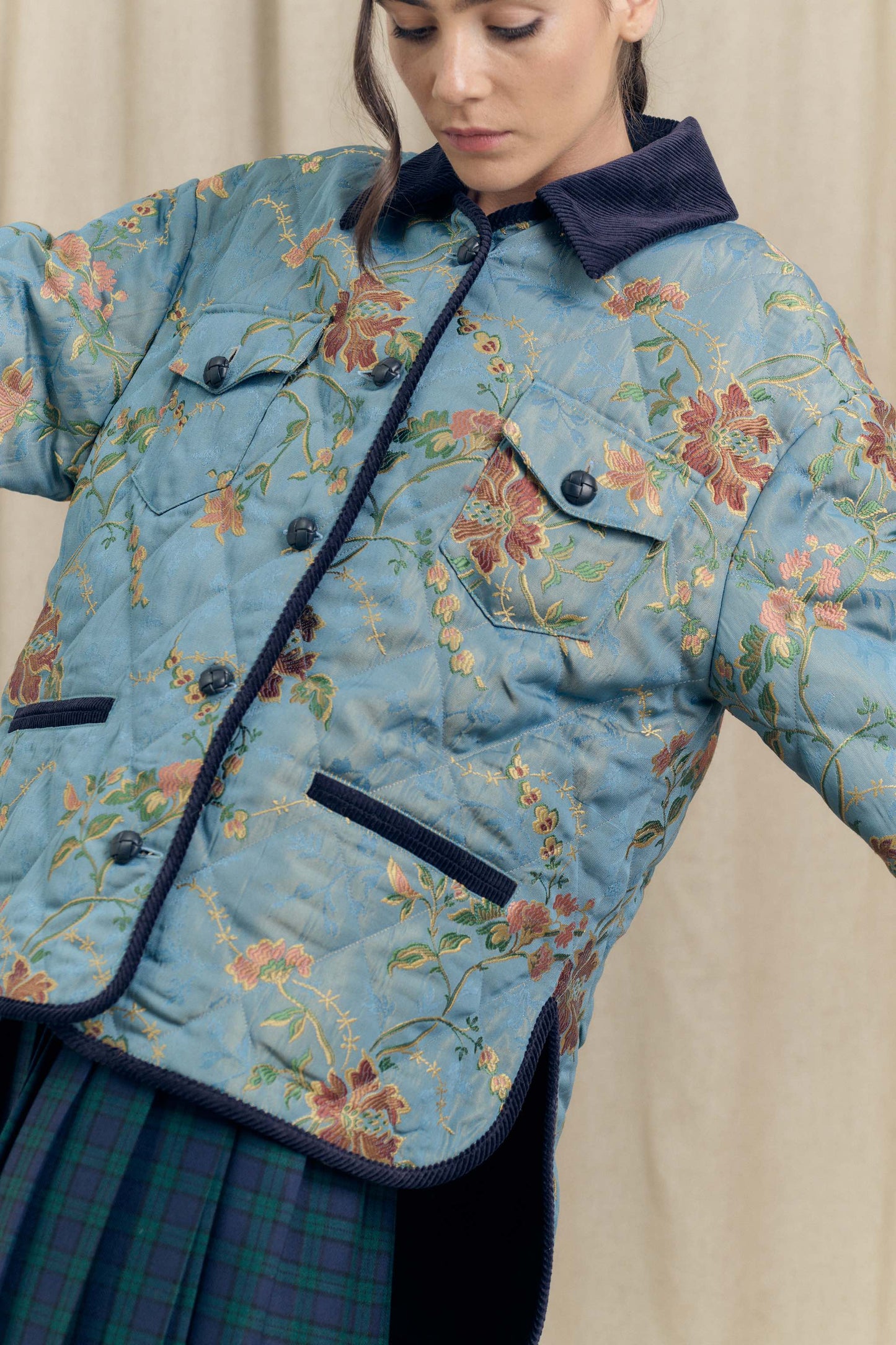 Close-up of the Botteghe Oscure Look 14 quilted jacket in floral lampas cotton highlighting the embroidered chinoiserie pattern and velvet finishing.