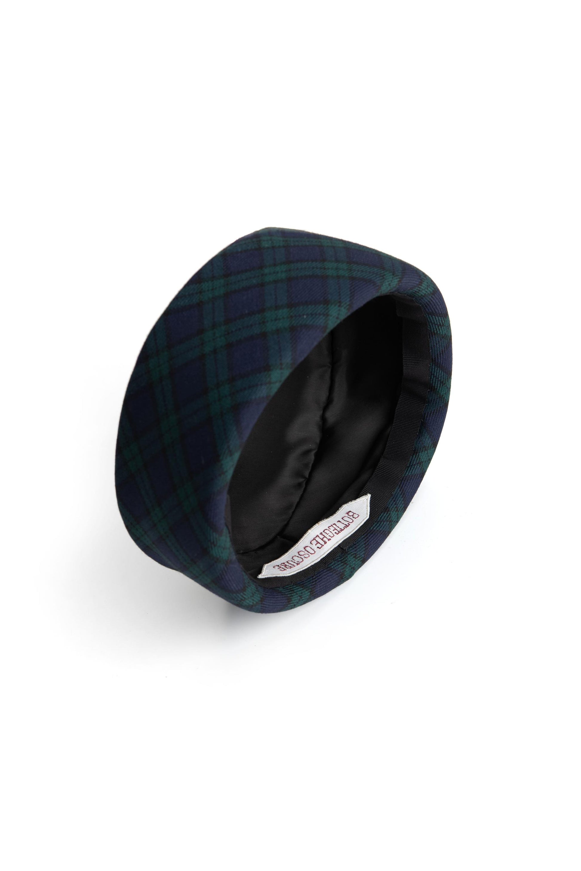Interior view of the Botteghe Oscure handmade pillbox hat in Black Watch wool with black viscose lining and artisan label.