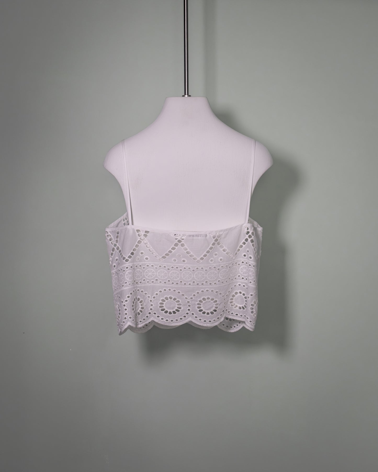 Back view of a white cotton batiste top with broderie anglaise embroidery and scalloped hem.