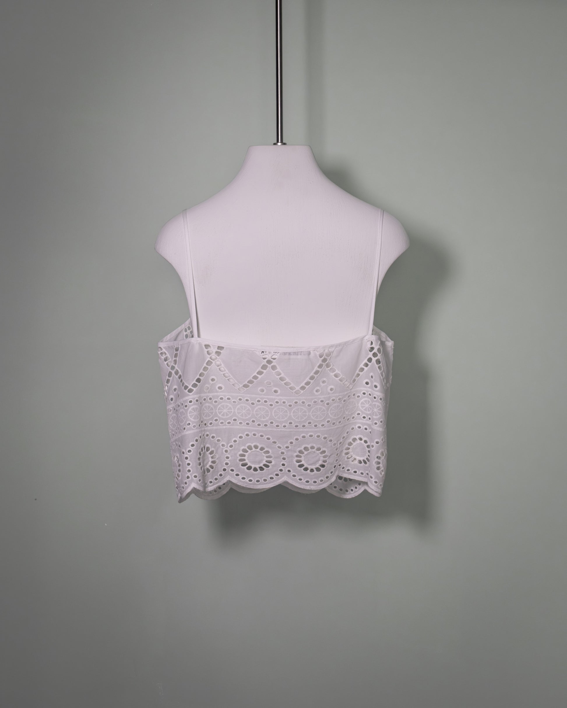 Back view of a white cotton batiste top with broderie anglaise embroidery and scalloped hem.