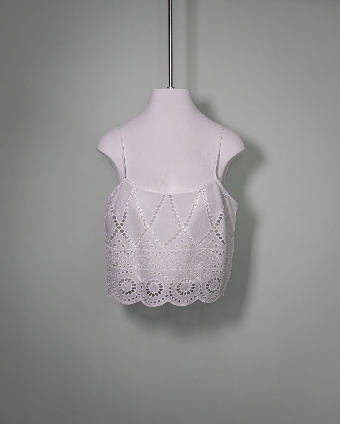 Front view of a white cotton batiste top featuring broderie anglaise embroidery and delicate spaghetti straps.