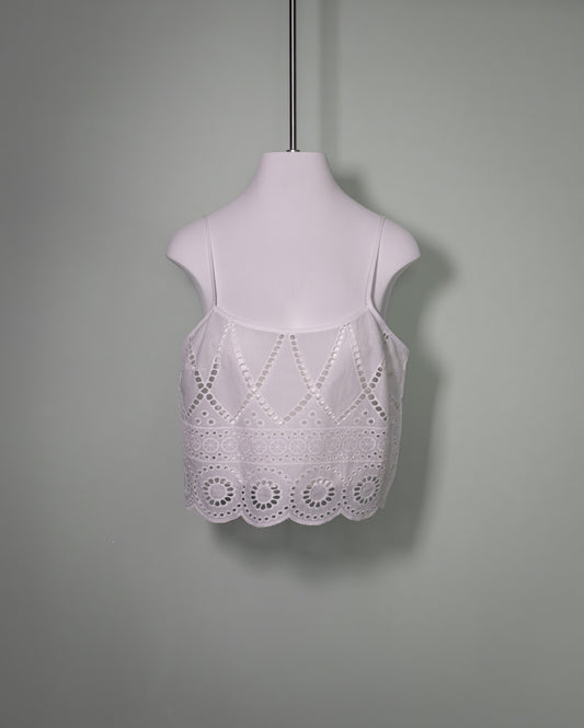 Front view of a white cotton batiste top featuring broderie anglaise embroidery and delicate spaghetti straps.