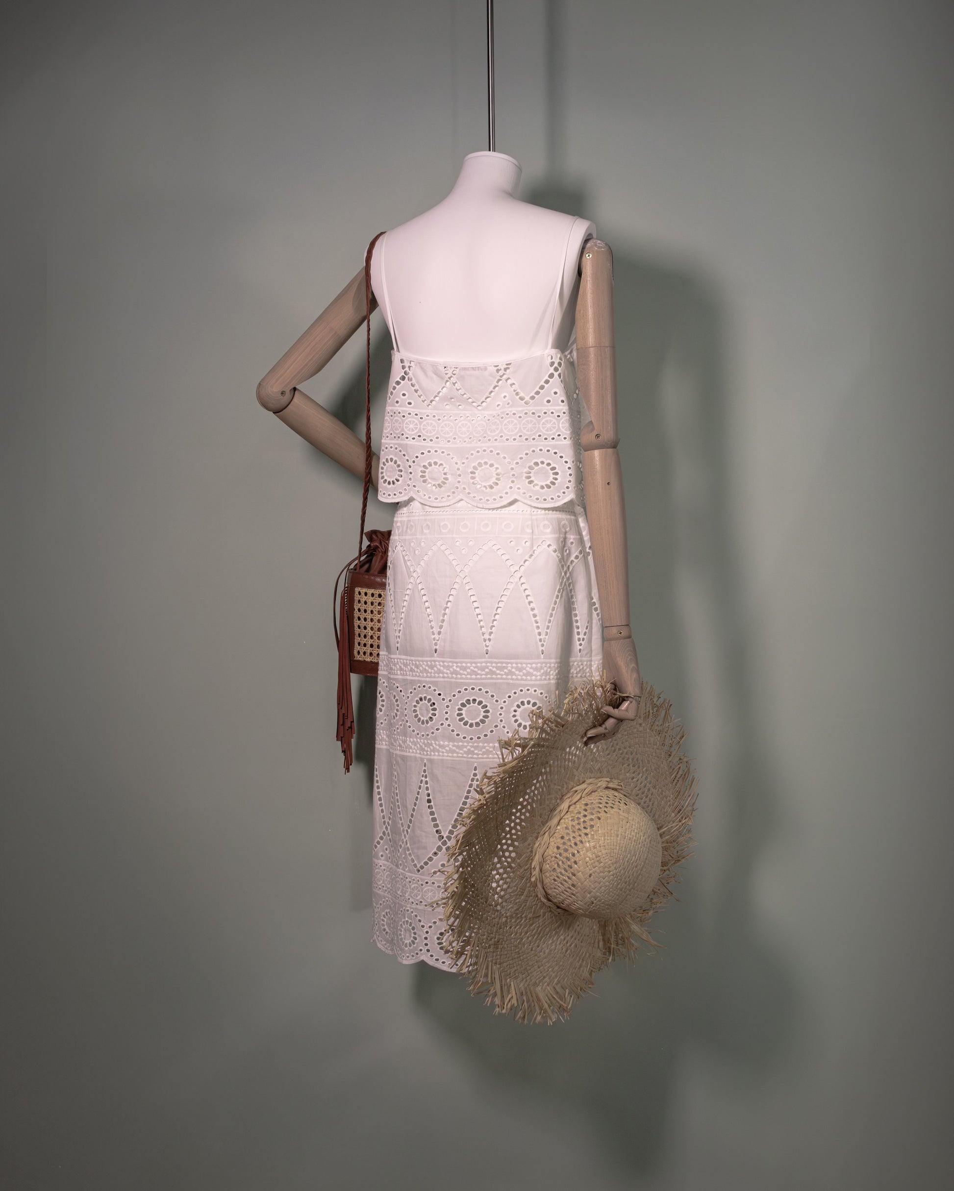 White cotton batiste top with broderie anglaise embroidery styled with the matching skirt and handcrafted bucket bag, back view.