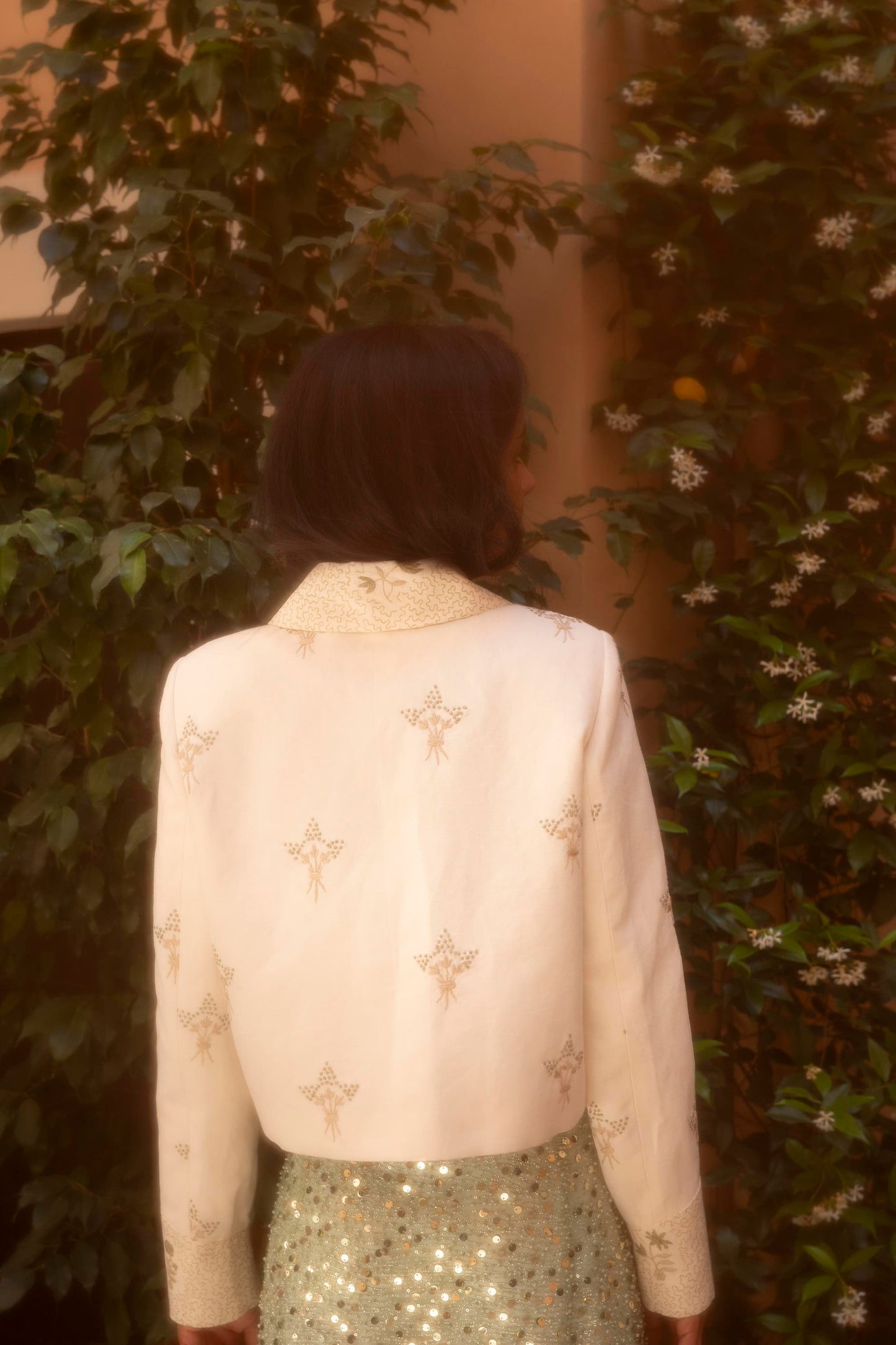 Botteghe Oscure Carré Jacket in archival English linen with hand-embroidered floral bouquets, styled in a complete editorial look, back view.