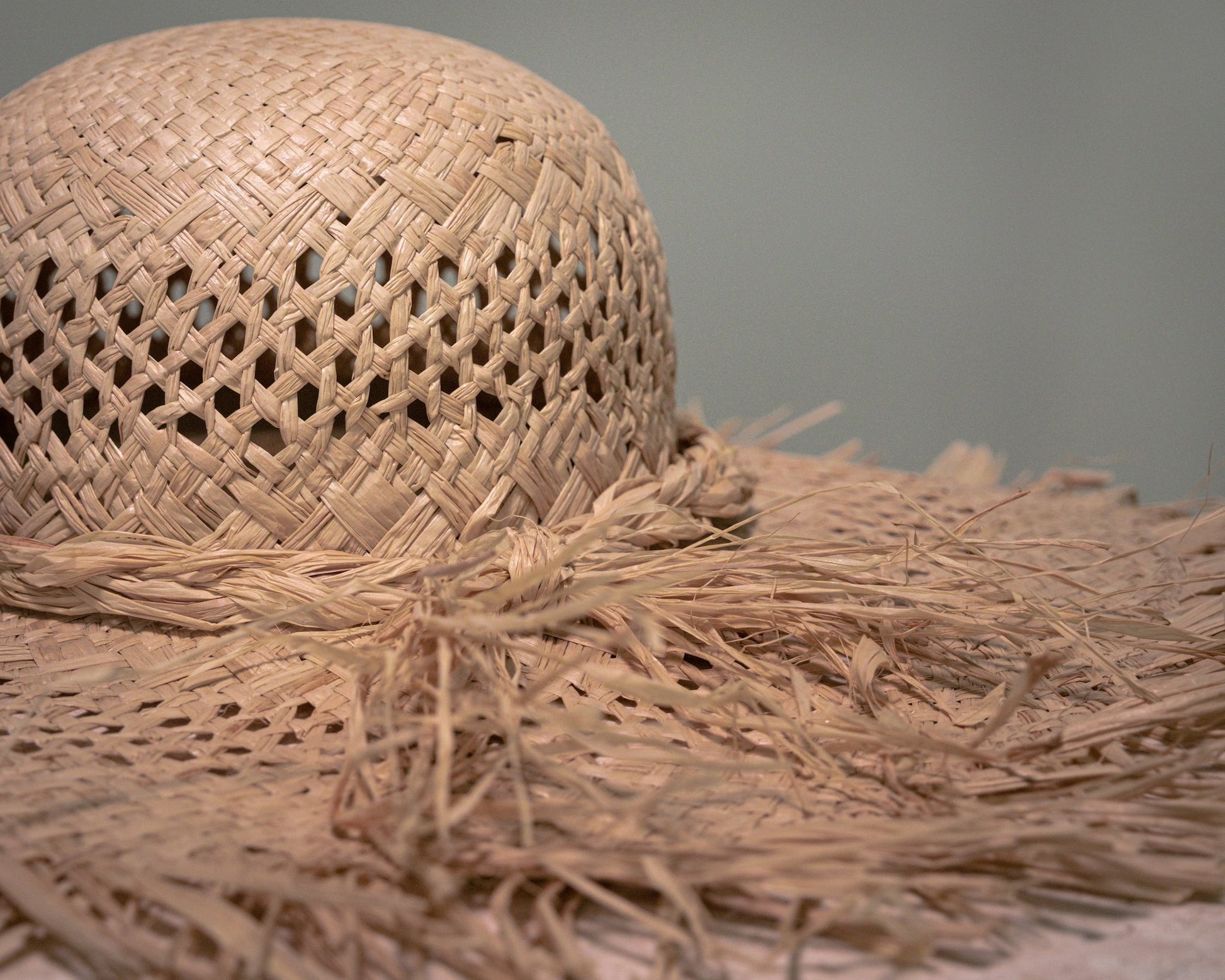 Detailed view of the open woven Vienna straw texture and handcrafted fringed brim.