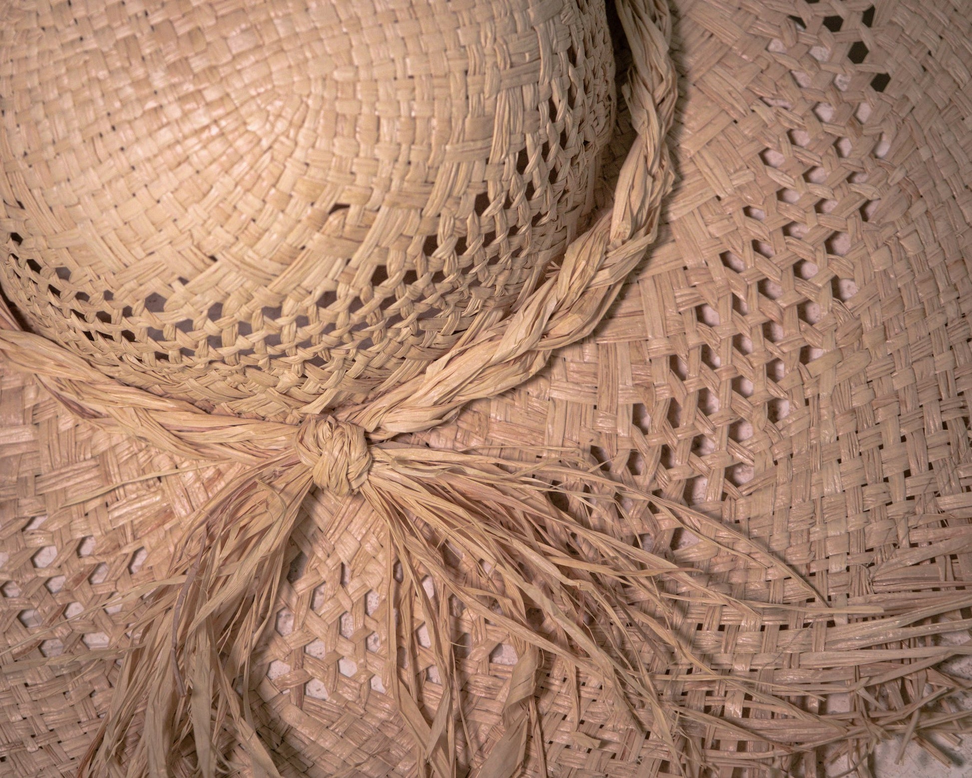 Close-up of the woven Vienna straw hat with side knot and fringed brim detail.