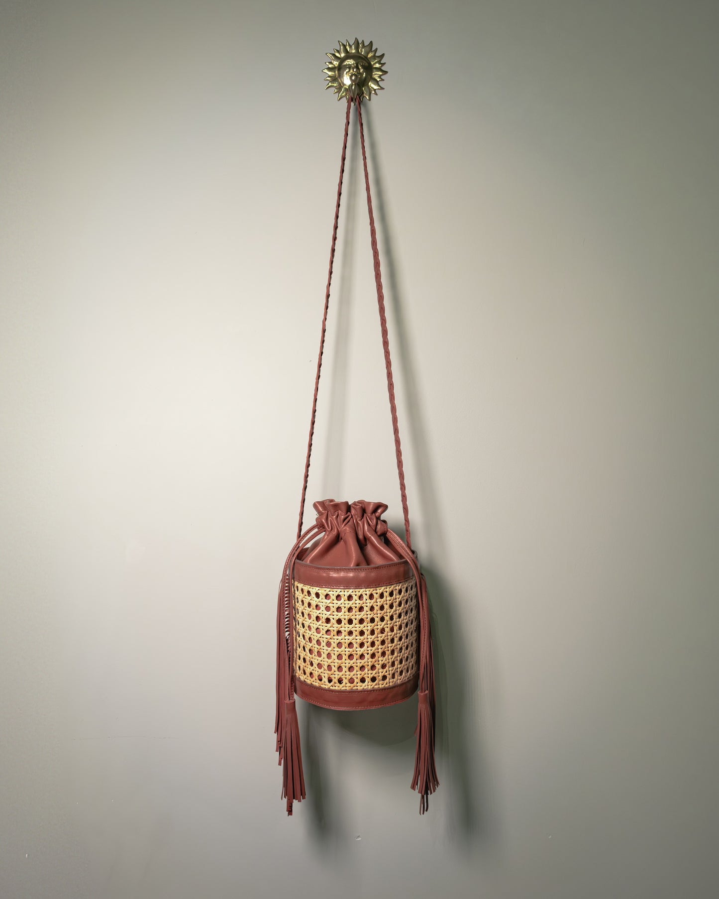 Handmade Vienna cane bucket bag with leather interior and braided shoulder strap by Botteghe Oscure.