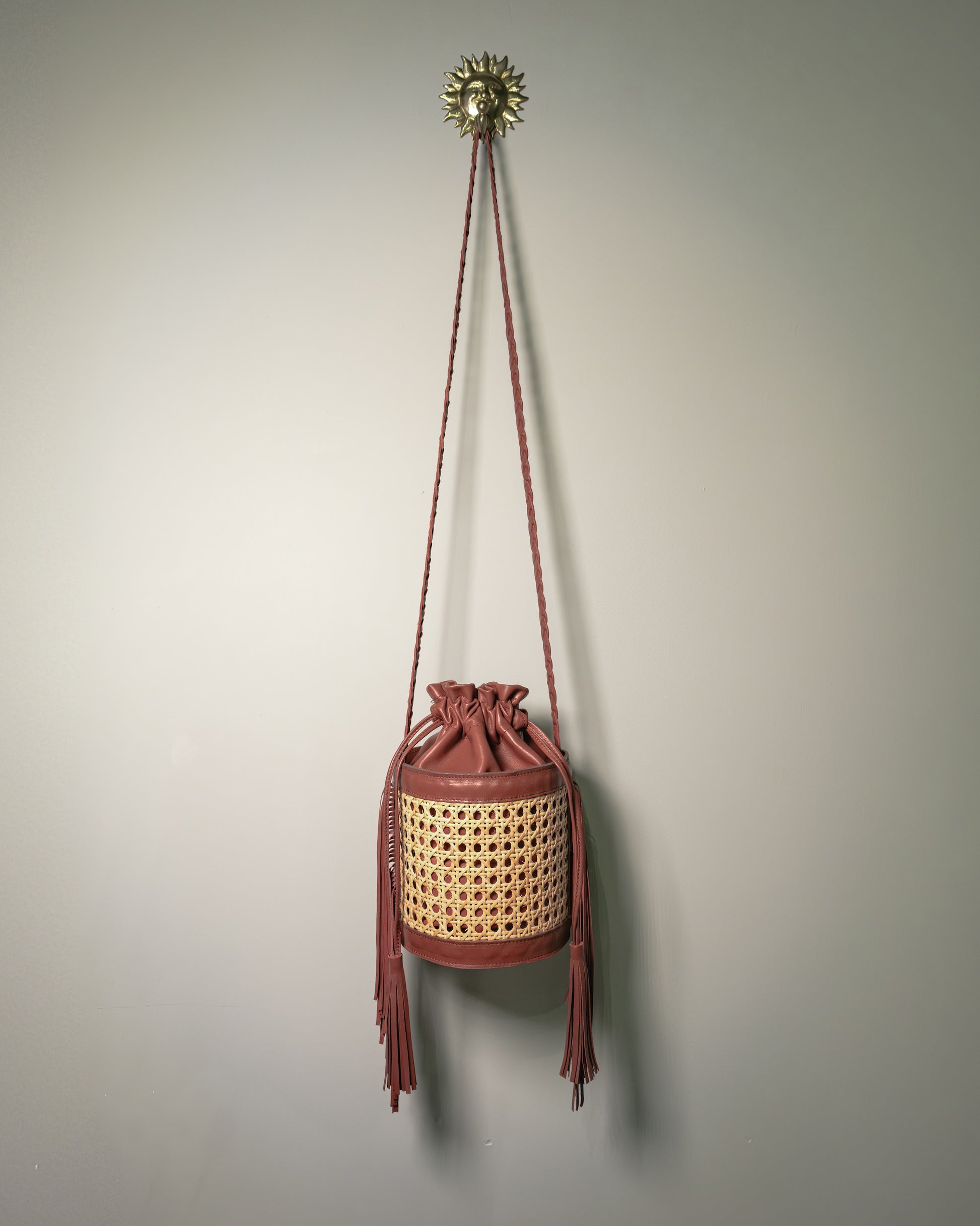 Handmade Vienna cane bucket bag with leather interior and braided shoulder strap by Botteghe Oscure.