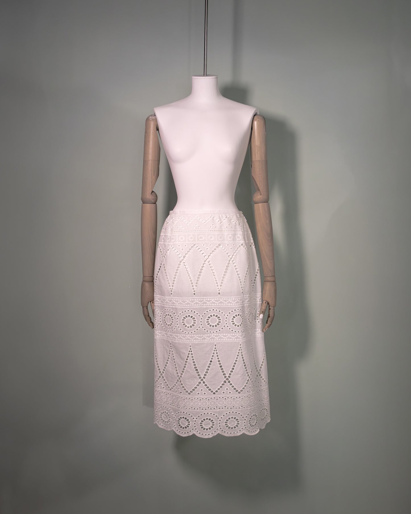 Front view of a white cotton batiste skirt featuring broderie anglaise embroidery and a scalloped hem.