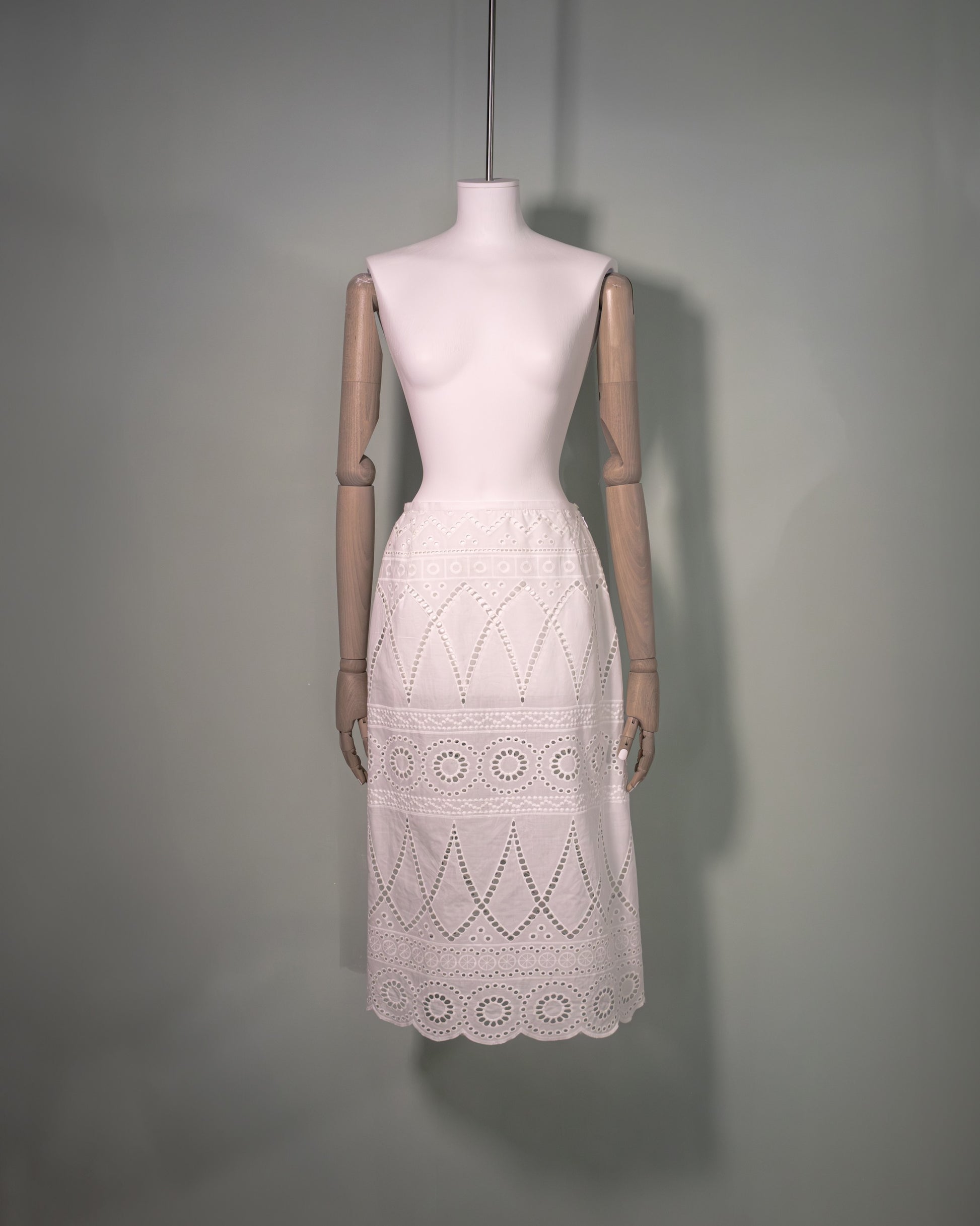 Front view of a white cotton batiste skirt featuring broderie anglaise embroidery and a scalloped hem.