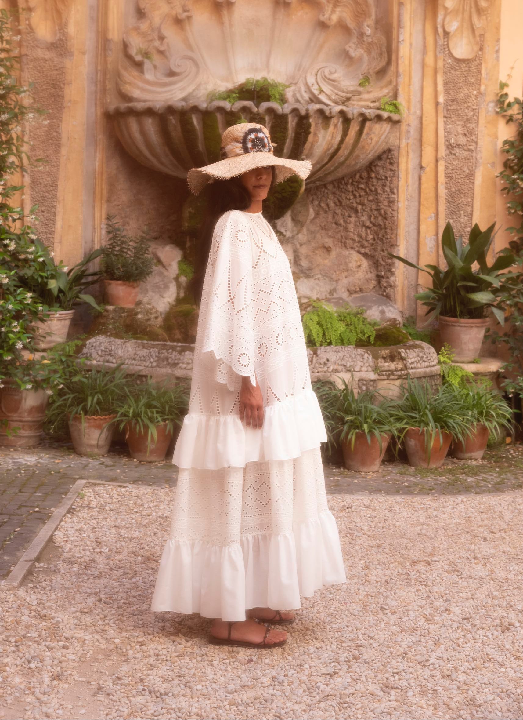 Broderie anglaise cotton batiste dress with gathered cotton voile tiers and handcrafted straw hat, front view.