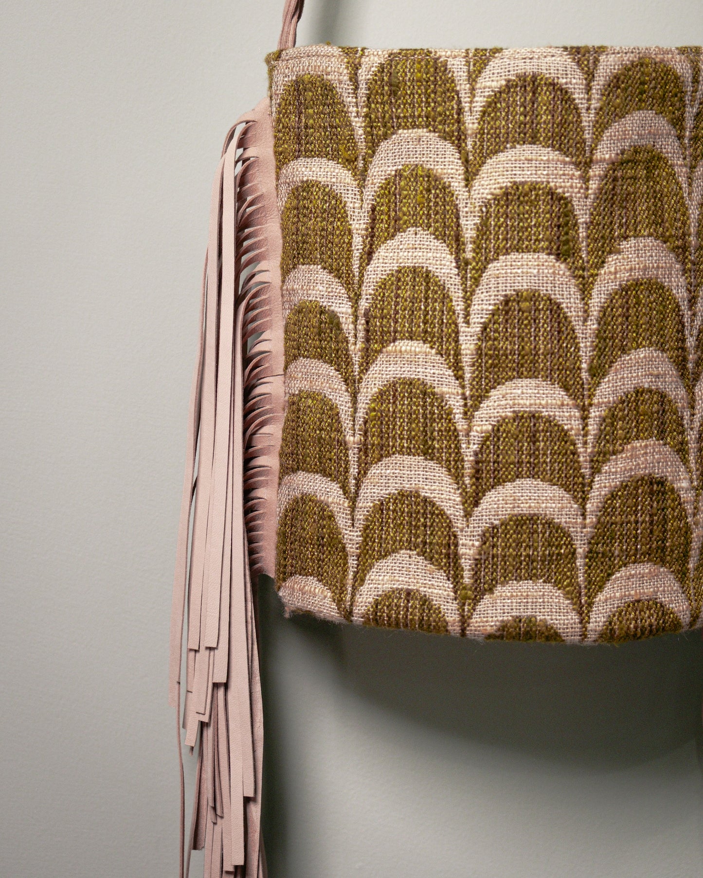 Detail of the archive palmette fabric and long nubuck leather fringes on the handmade bucket bag.