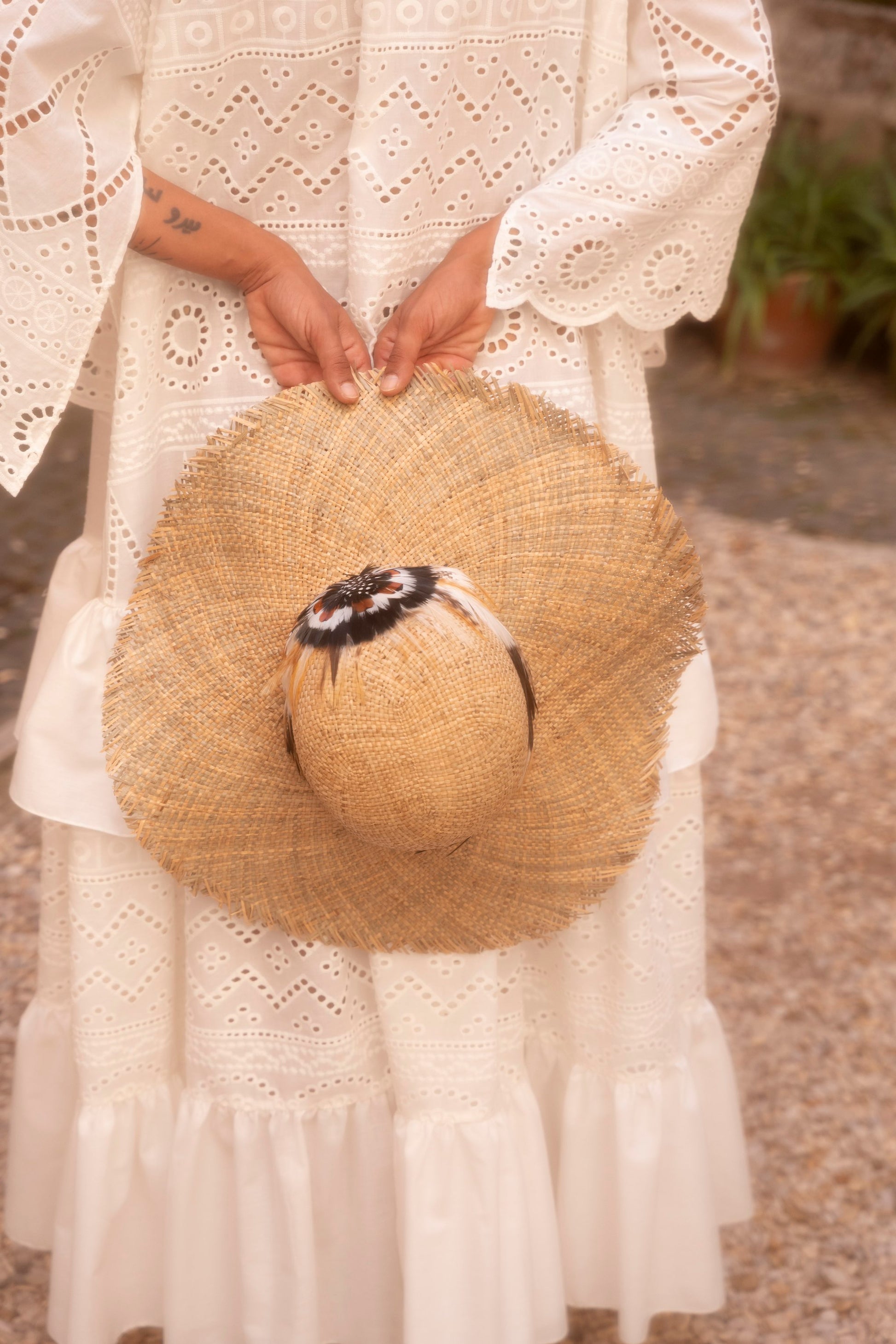 Handmade feather straw hat worn with embroidered garment by Botteghe Oscure.