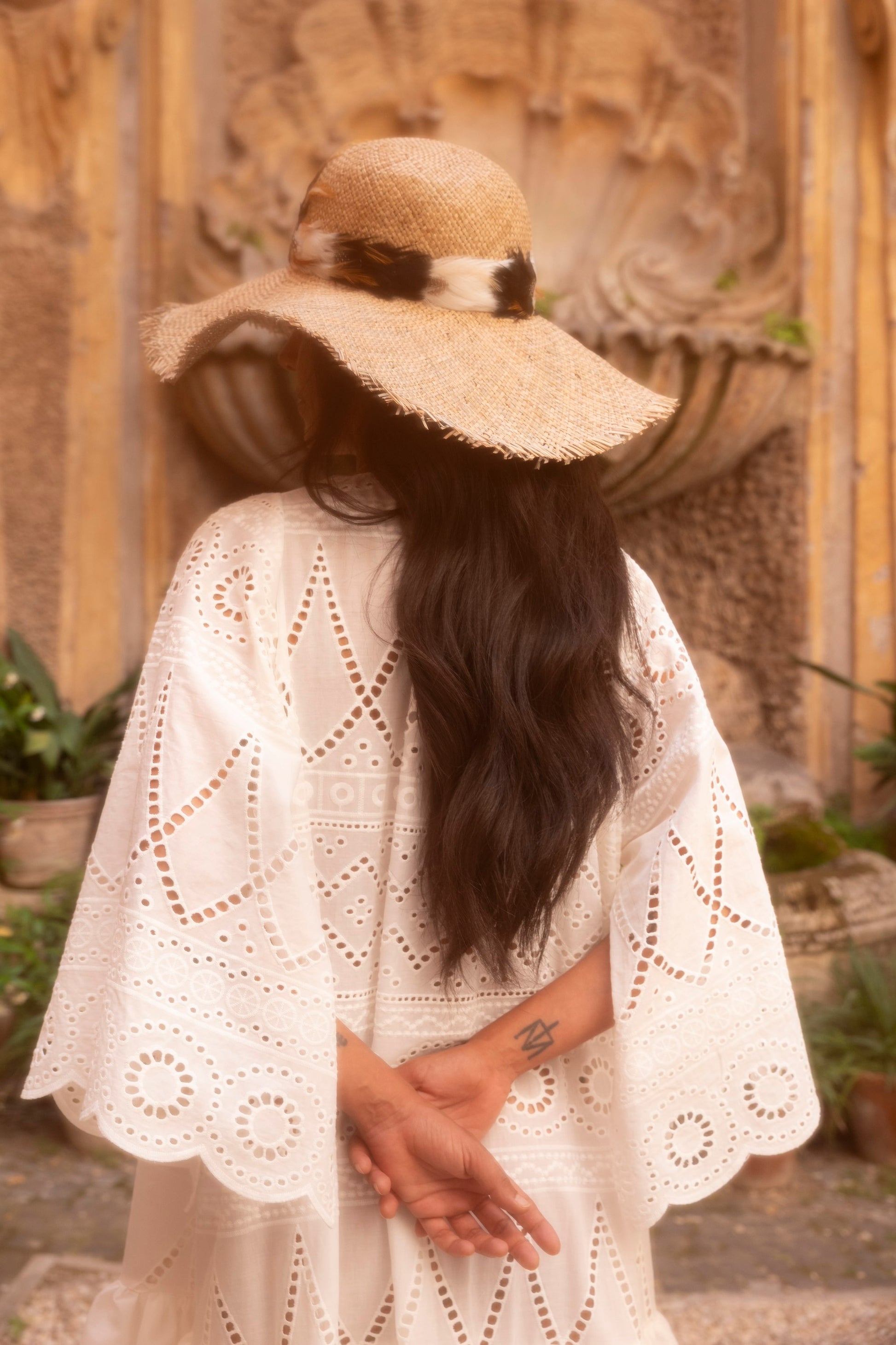 Handmade feather straw hat worn with embroidered garment by Botteghe Oscure.