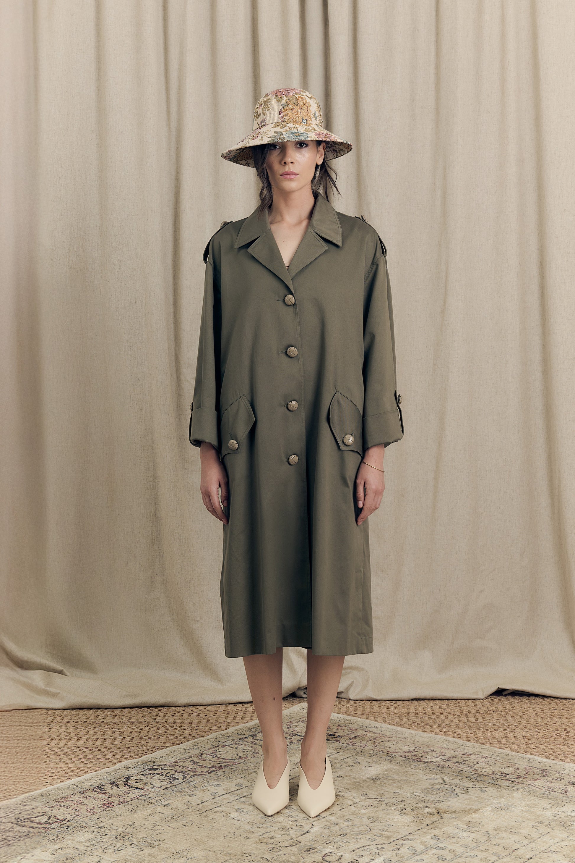 Front view of oversized green parka in cotton drill with hand-pleated back and leather buttons – Botteghe Oscure