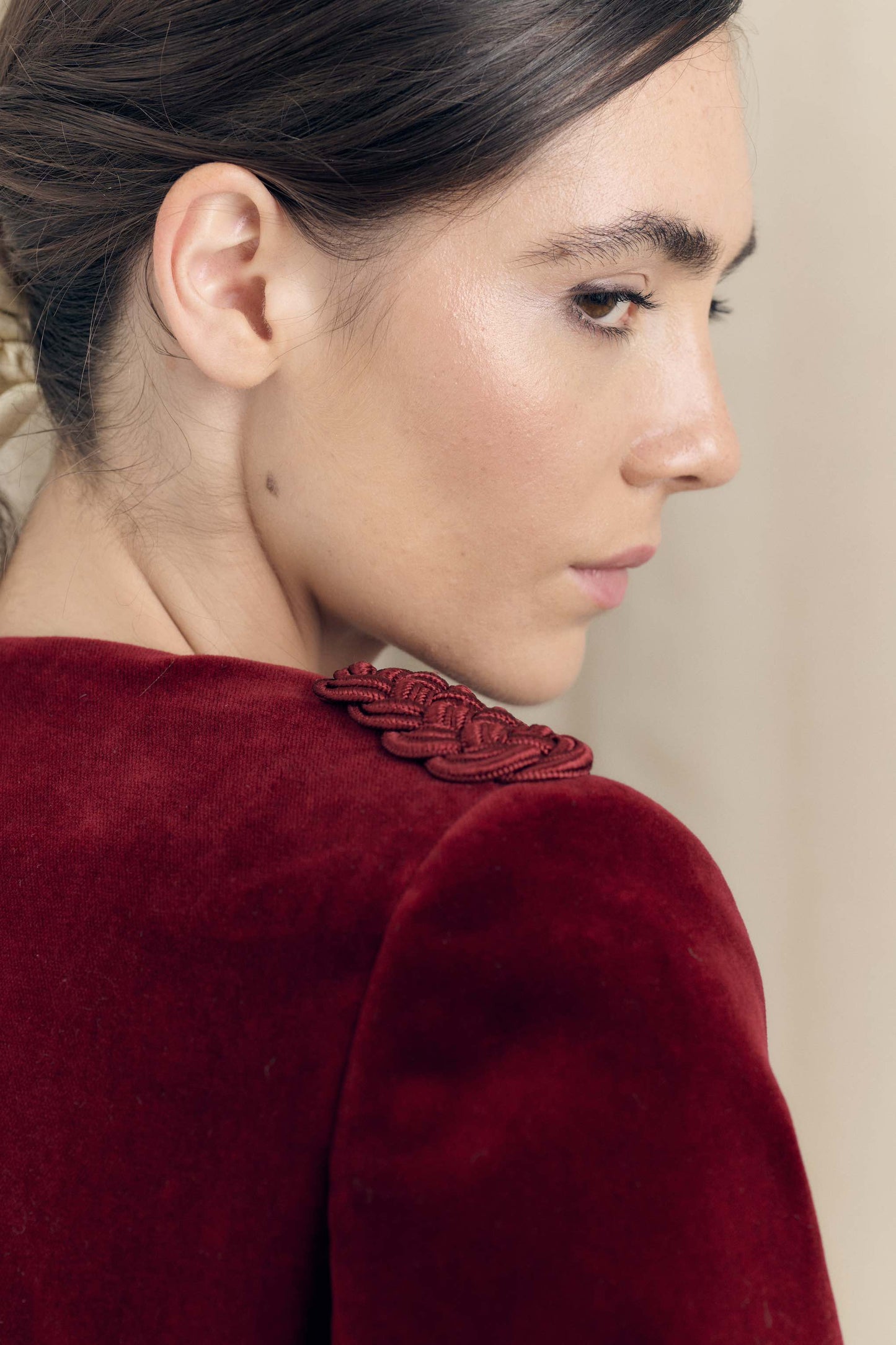 Detail of Botteghe Oscure Brandebourg jacket shoulder with handcrafted shoulder embellishment in bordeaux velvet.