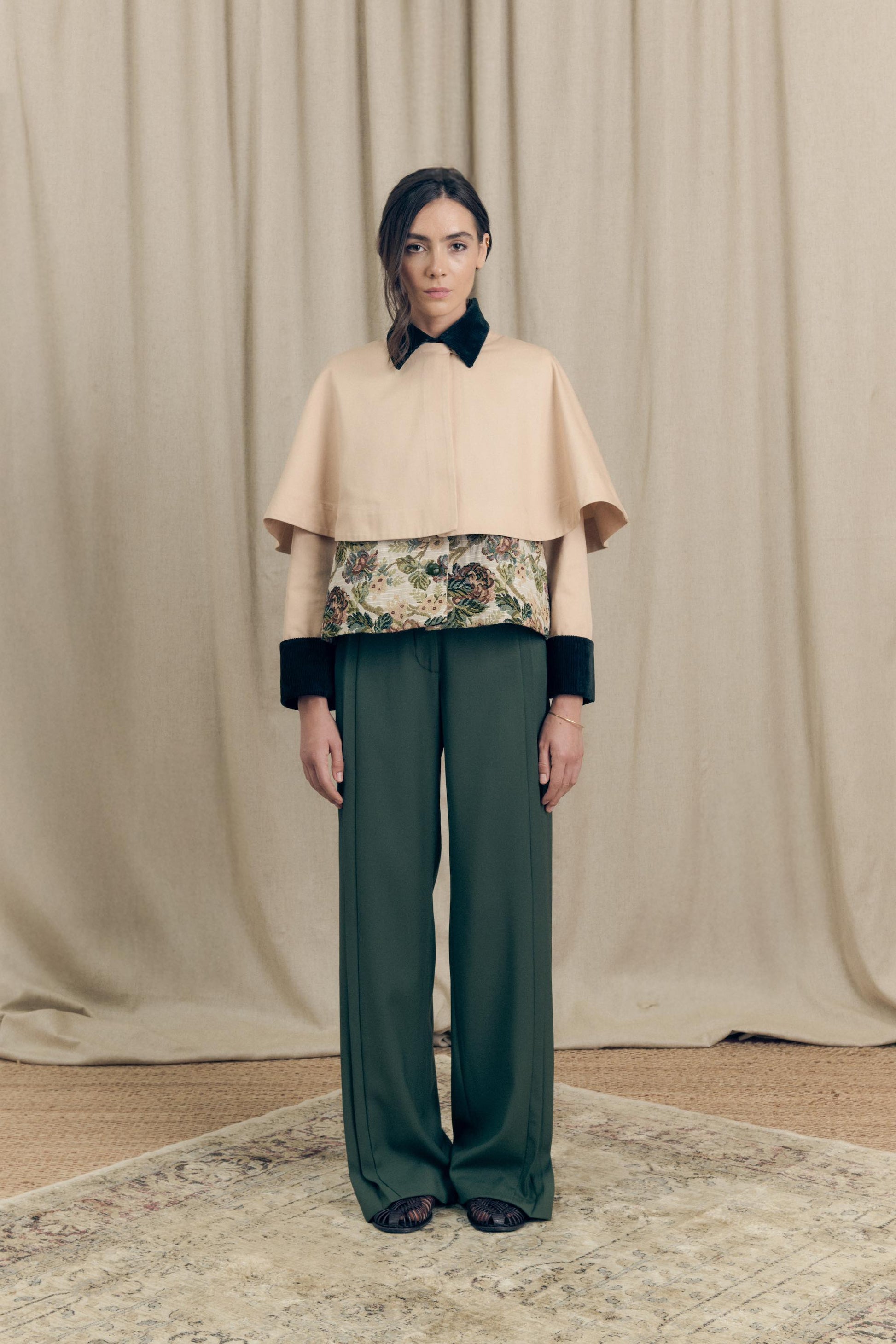 Front view of the Heatherfield Jacket by Botteghe Oscure, showcasing the structured silhouette, removable capelet in cotton twill, floral jacquard body, and velvet collar with leather-woven buttons.