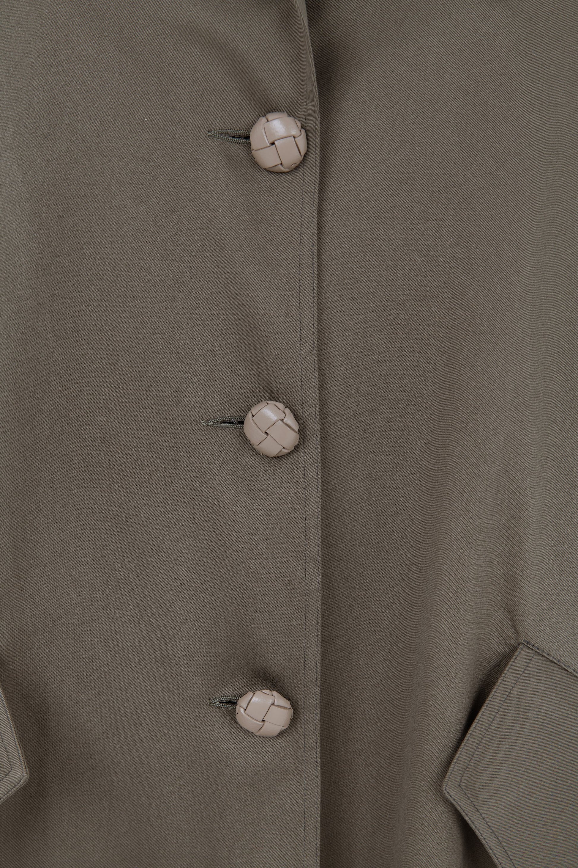 Close-up of braided leather buttons on cotton  oversized parka with pleated back  – Botteghe Oscure