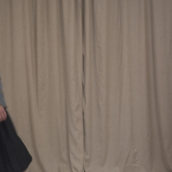 Model walking wearing the Botteghe Oscure Look 14 workwear quilted jacket in floral lampas cotton with navy velvet details, styled with a tartan pleated skirt and boots