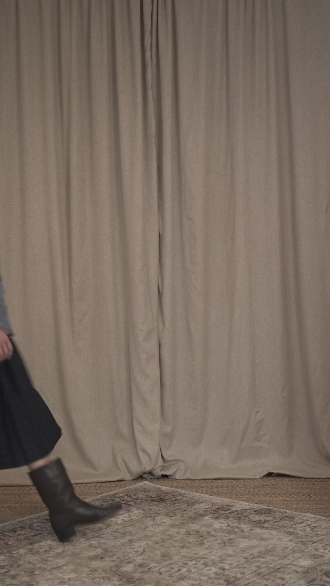 Model walking wearing the Botteghe Oscure Look 14 workwear quilted jacket in floral lampas cotton with navy velvet details, styled with a tartan pleated skirt and boots