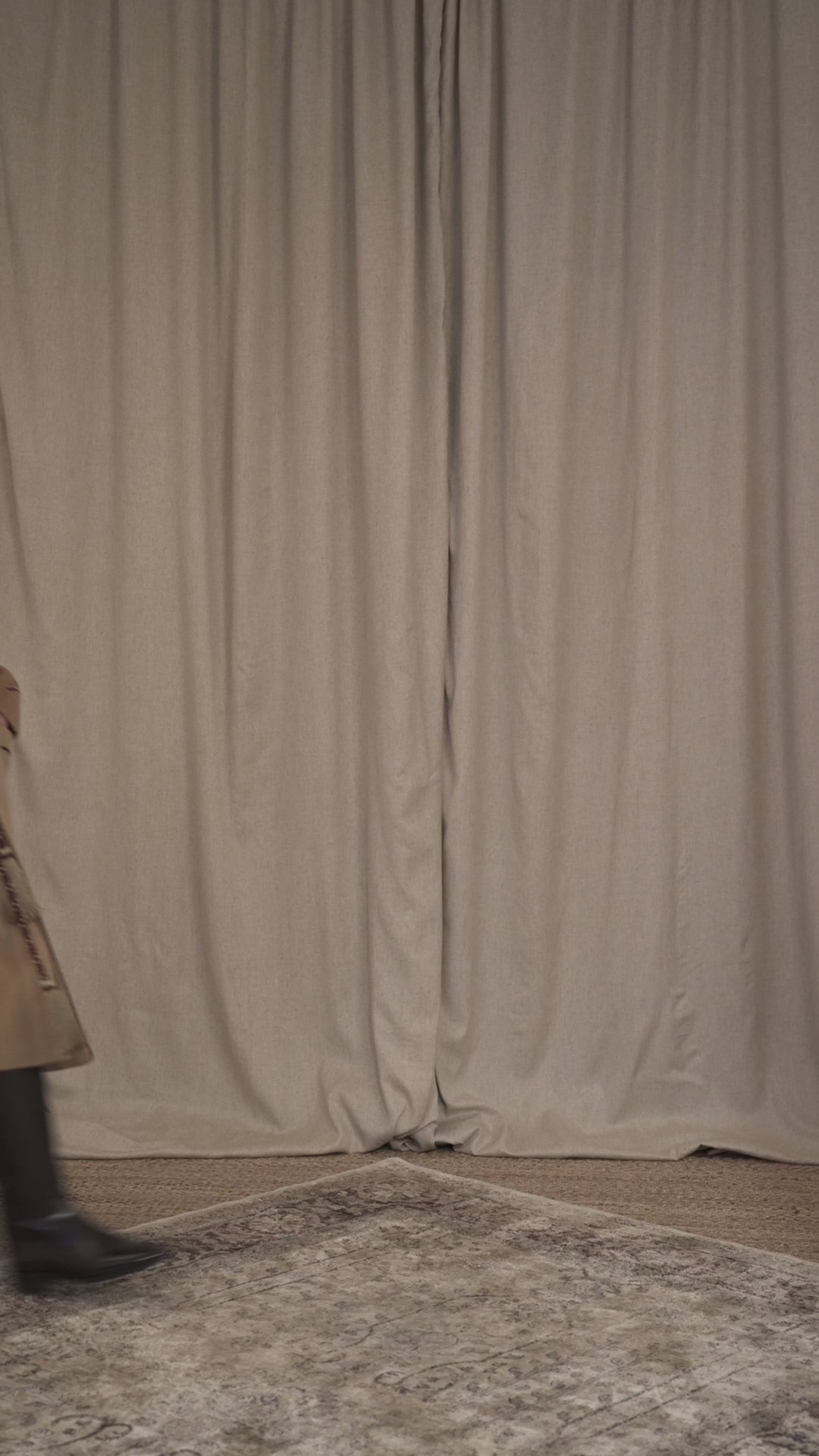 Model walking wearing a camel combed wool wrap coat inspired by historic dressing gowns, featuring bi-colour twisted cord detailing, a perlé cord belt with tasselled ends and a contrasting burgundy lining, Botteghe Oscure.