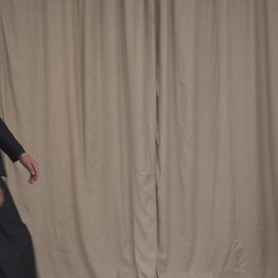 Model walking in belted military blazer and matching Black Watch tartan trousers by Botteghe Oscure.