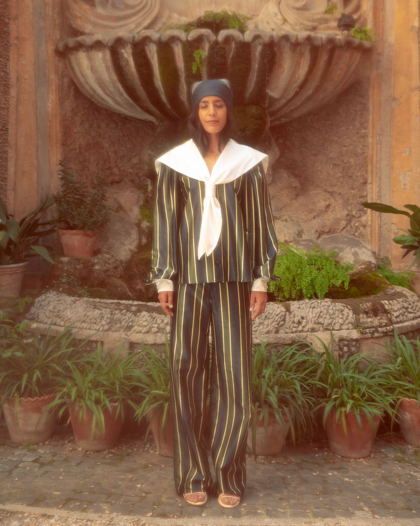 Model wearing oversized sailor shirt by botteghe Oscure in cotton and silk blend with a large silk pleated collar, front view.